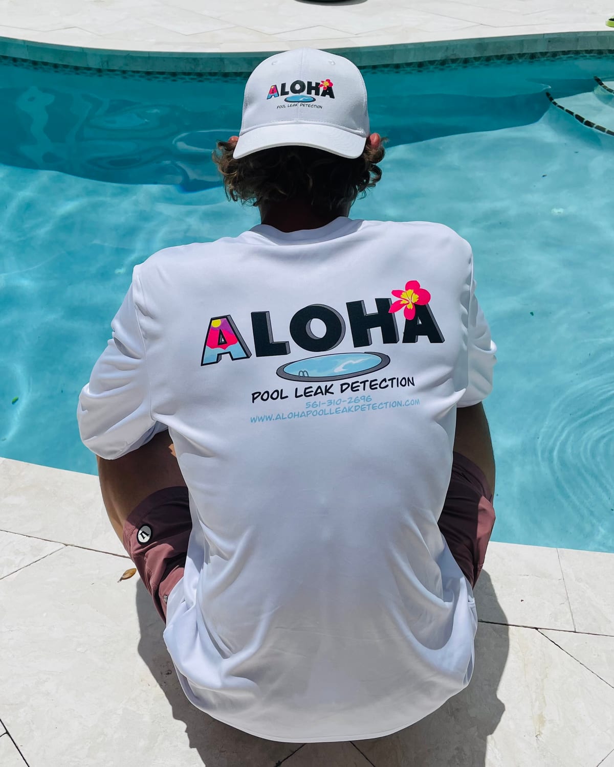 Tyler Thompson poolside in his Aloha Pool Leak Detection shirt and cap